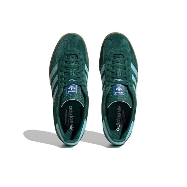 Pair of dark green sneakers with light blue stripes and lace-up design