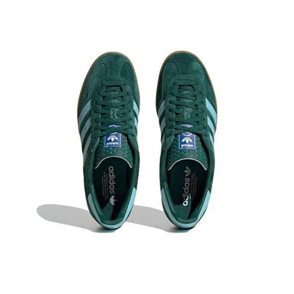 Pair of dark green sneakers with light blue stripes and lace-up design