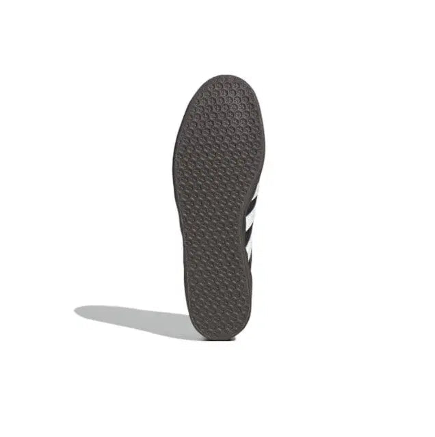 Gazelle indoor sneakers outsole, dark textured tread with white stripe accents