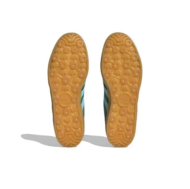 Tan gum outsole with circular tread pattern on dark green sneakers