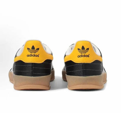 Adidas Gazelle indoor sneakers, rear view; yellow collar, black panels, gum soles