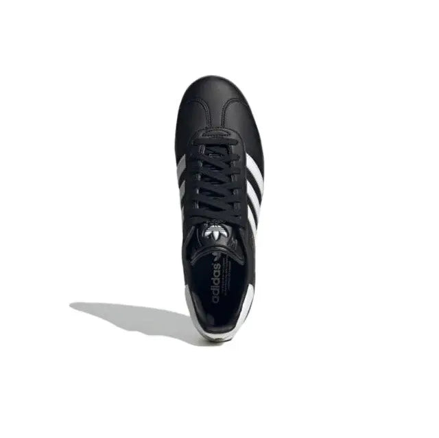 Gazelle indoor sneakers front view, black upper with white stripes and lace-up