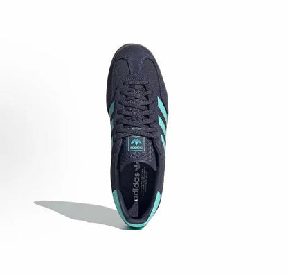 Adidas Gazelle Indoor sneaker with dark navy upper, lace-up front, turquoise 3-Stripes.