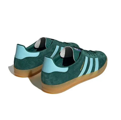 Dark green suede sneakers with light blue heel tab, striped sides, and gum sole