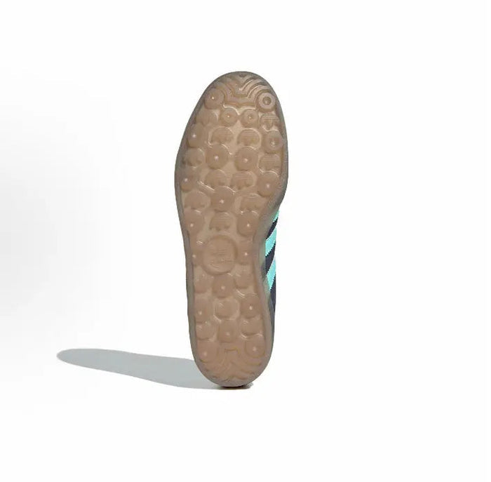 Adidas Gazelle Indoor sneaker outsole view with textured light-brown rubber and turquoise stripe edge.