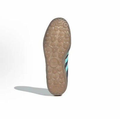 Adidas Gazelle Indoor sneaker outsole view with textured light-brown rubber and turquoise stripe edge.