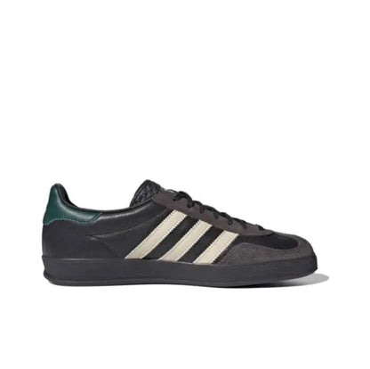 Low-top sneakers with dark suede, cream stripes, green heel tab, and black rubber sole
