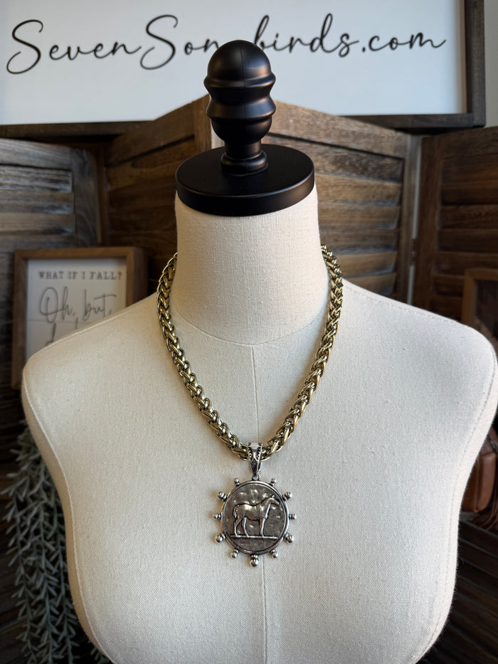 Horse coin medallion pendant necklace on mannequin with gold-tone chain and round charm