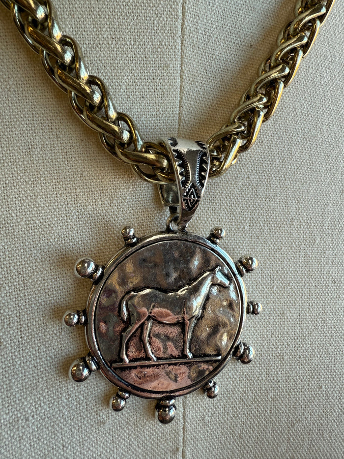 Round horse coin pendant necklace with gold-tone chain and spiked bead accents