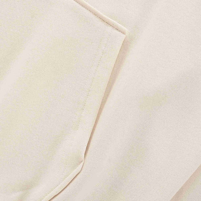 Beige hoodie fabric close-up with stitched seam and folded sleeve cuff edge