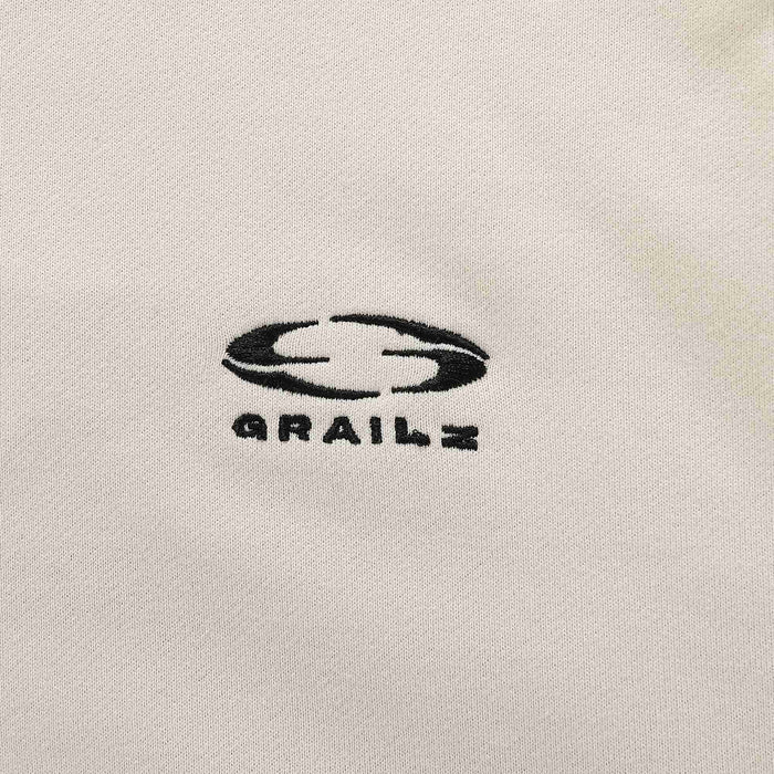 Beige hoodie chest logo with stylized graphic and text.
