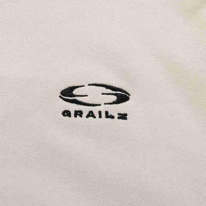 Beige hoodie chest logo with stylized graphic and text.