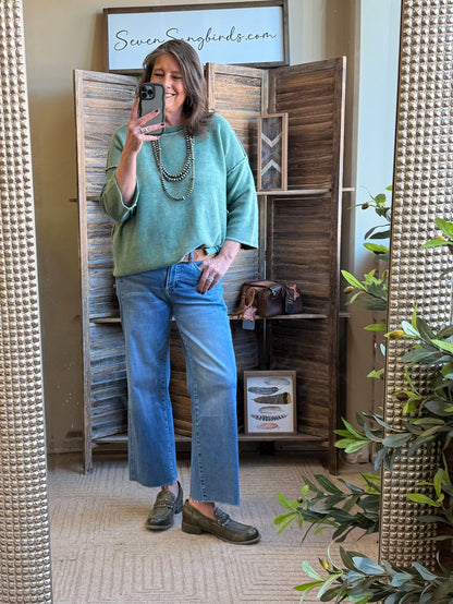 Green cotton 3/4 sleeve sweater with boat-style neckline, paired with blue jeans