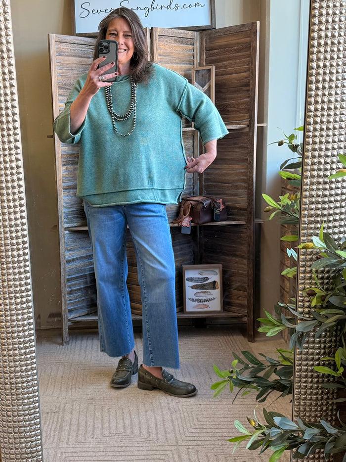 Green cotton 3/4 sleeve sweater worn with blue jeans and necklace