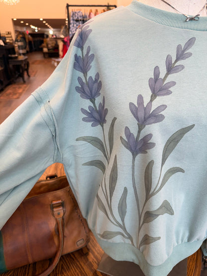 Floral watercolor sweatshirt in light blue with purple flower sprig print across chest