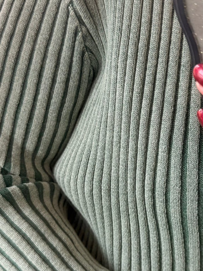 Green mineral-wash ribbed knit fabric with visible zip placket edge