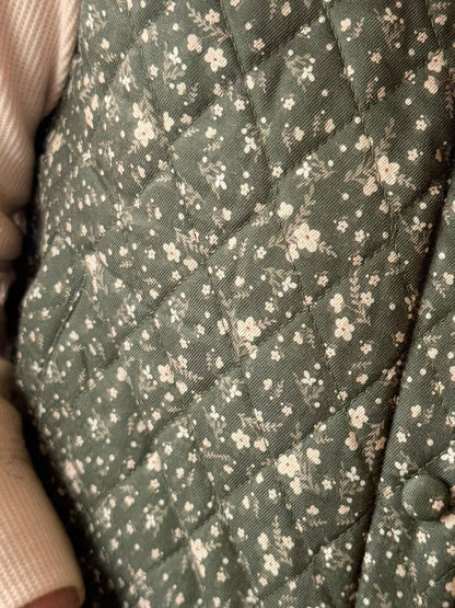 Close-up of dark green floral cotton vest showing dense small blossom pattern