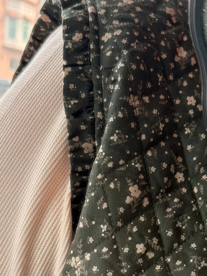 Close-up of dark green mini floral cotton vest fabric with small flower print