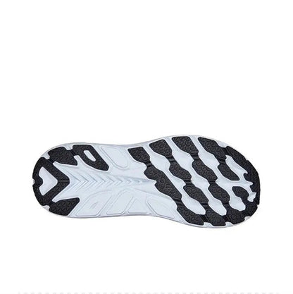 Running shoe outsole view with black traction lugs on a white base