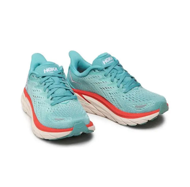 Pair of teal running shoes with red accents and white midsoles