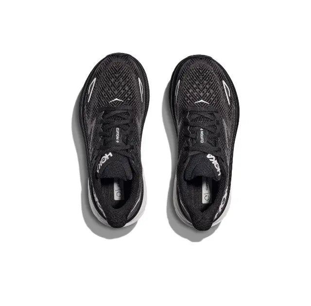 Pair of black lace-up running shoes viewed from top, HOKA branding on uppers
