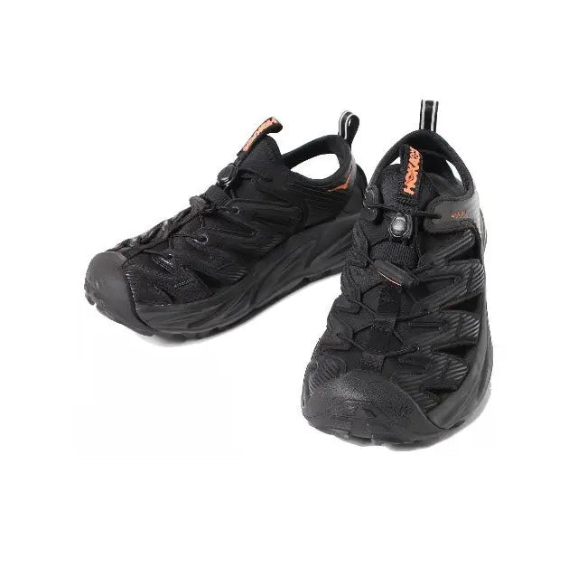 Trail shoe pair, black with orange heel tab and lace-up front