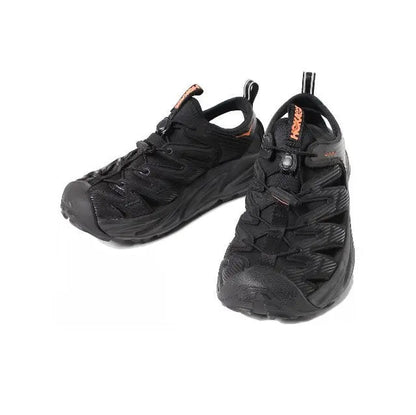 Trail shoe pair, black with orange heel tab and lace-up front