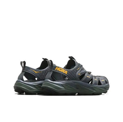 Trail sandal side view, dark navy upper with yellow logo and olive-green sole