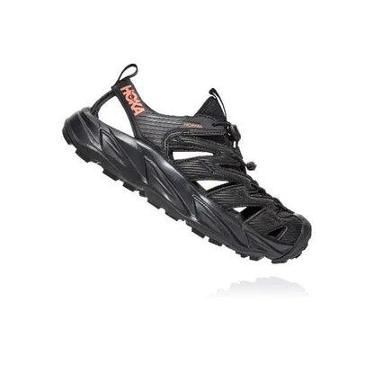 Trail shoe angled view, black with hook-and-loop strap and lace-up closure