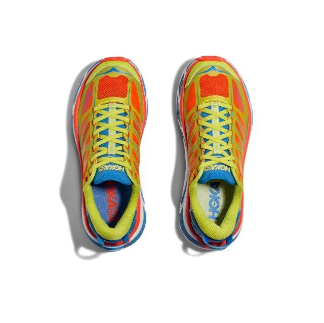 Trail running shoe top view with neon green upper, red toe, and blue tongue