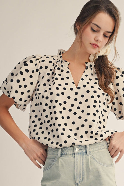 Ivory V-neck polka dot shirt with short puff sleeves and black dot pattern