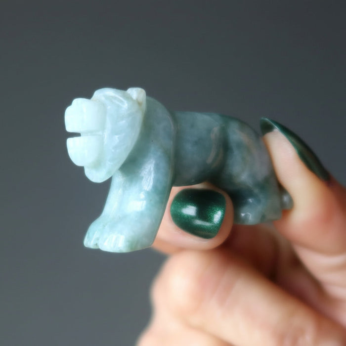 hand holding green jade tiger carving