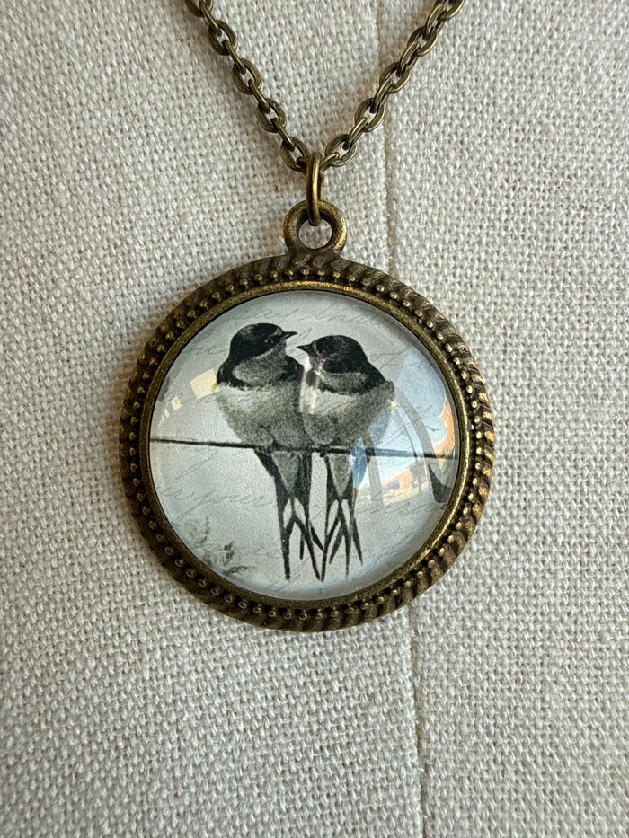Round glass bird pendant on bronze chain