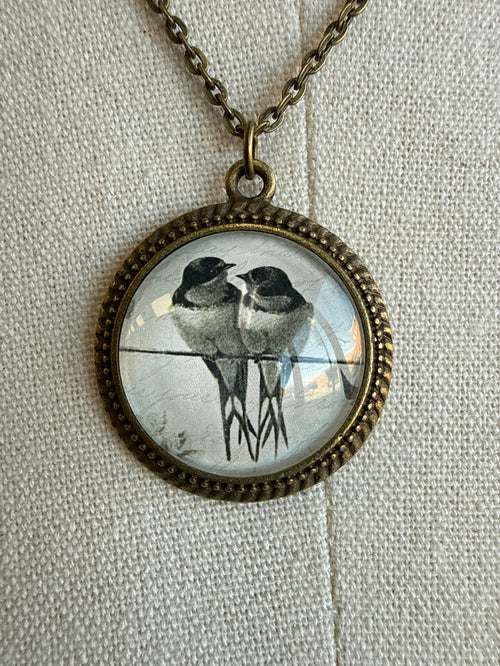 Round glass bird pendant on bronze chain
