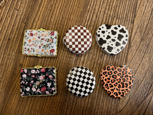 Assorted mirror compacts set with floral, checker, cow-print and leopard-heart patterns