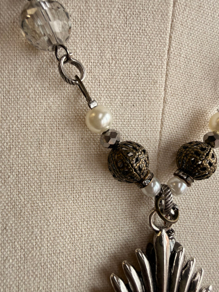Heart pendant necklace with gunmetal sunburst, black beads, and white pearl accents