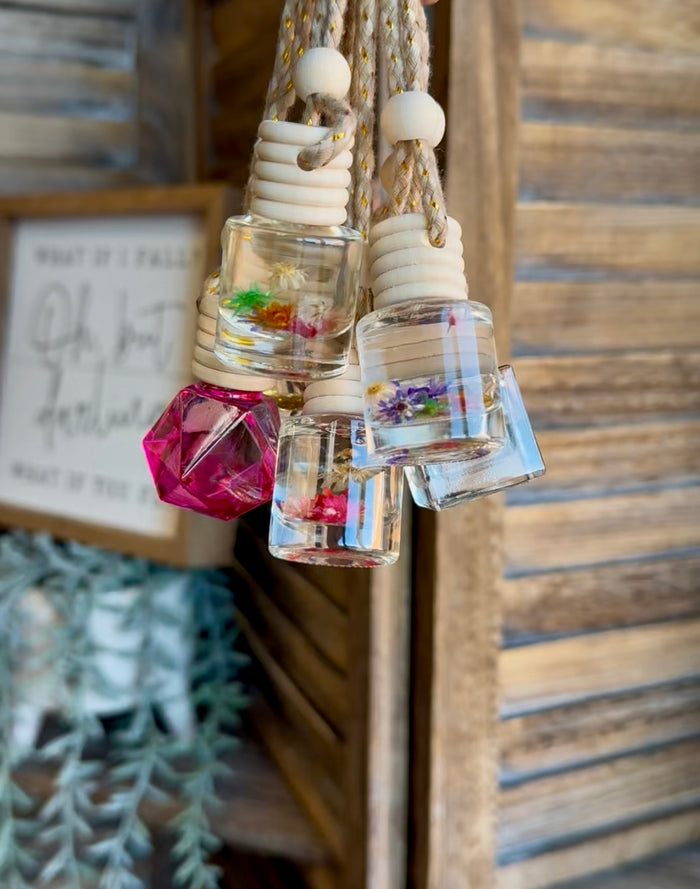 Decorative reed scent diffuser with clear bottle, white top, and pink faceted glass