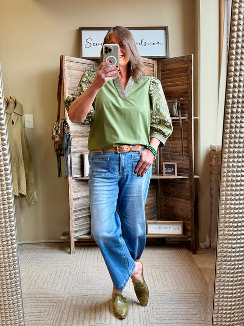Olive green embroidered sleeve V-neck shirt, front view with detailed cuffs