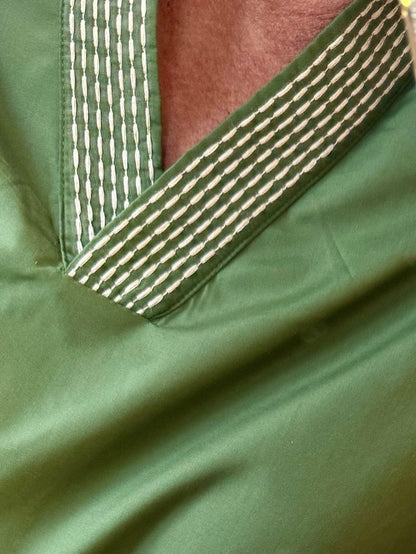 Olive green V-neck shirt with cream embroidered trim along collar seam