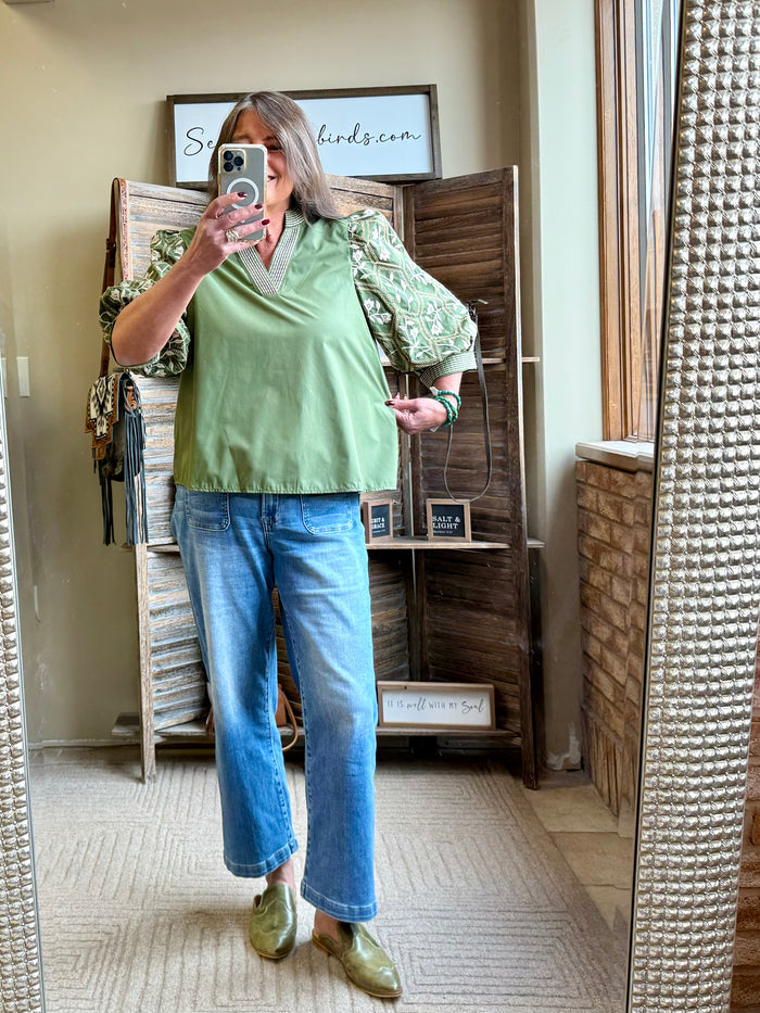Olive green embroidered sleeve V-neck shirt with cream trim and roomy fit