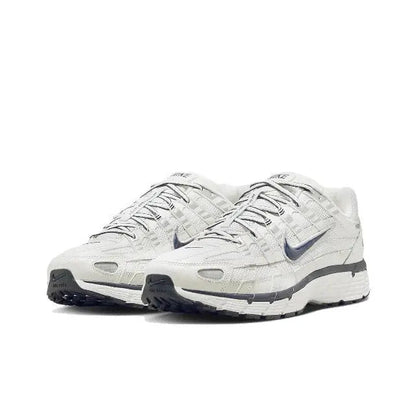 White running sneaker with blue swoosh, lace-up side profile