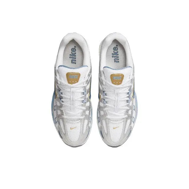 White sneakers with laced uppers and Nike tongue label, gold heel emblem