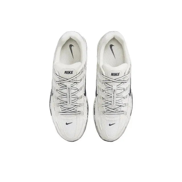 Pair of white lace-up Nike running sneakers, heel and tongue details