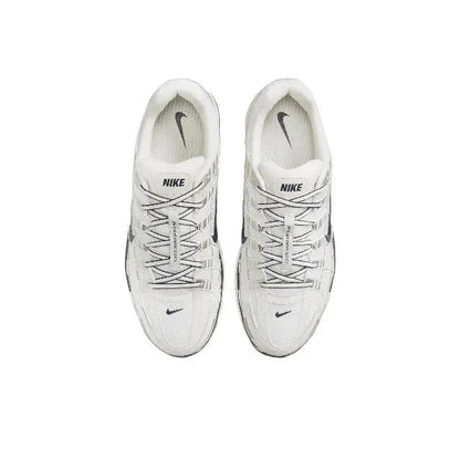 Pair of white lace-up Nike running sneakers, heel and tongue details