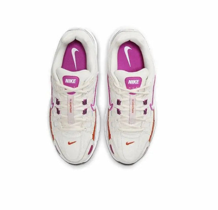White sneaker pair with purple swoosh on tongue and red lace detail