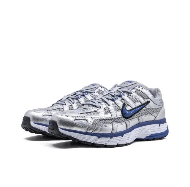Nike running shoe front view in silver and blue, lace-up with textured overlays.