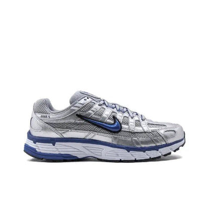 Nike running shoe side view in silver and blue, perforated panels and Swoosh.