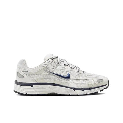 White Nike running sneaker, side profile with blue swoosh and lace-up