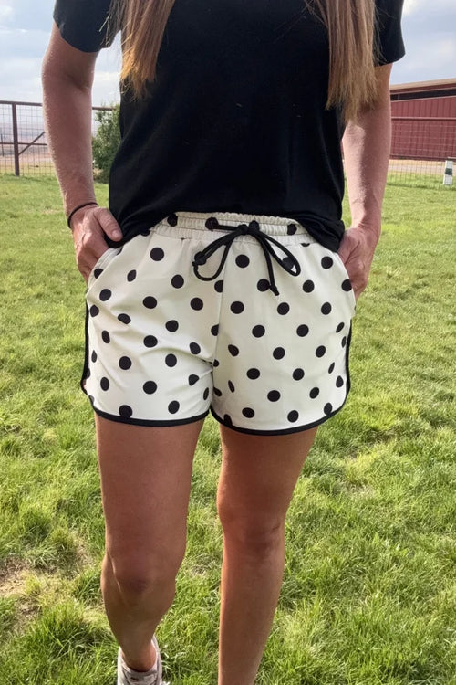 White polka-dot shorts with black drawstring and elastic waistband