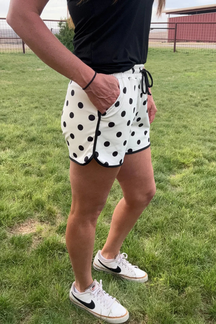 Polka-dot shorts in white with black dots, black drawstring and elastic waist